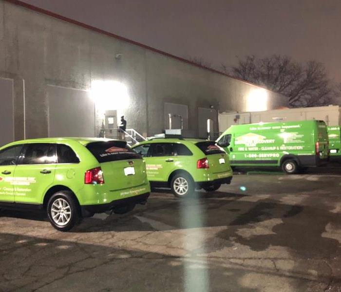 Green SERPRO trucks in a parking lot. 