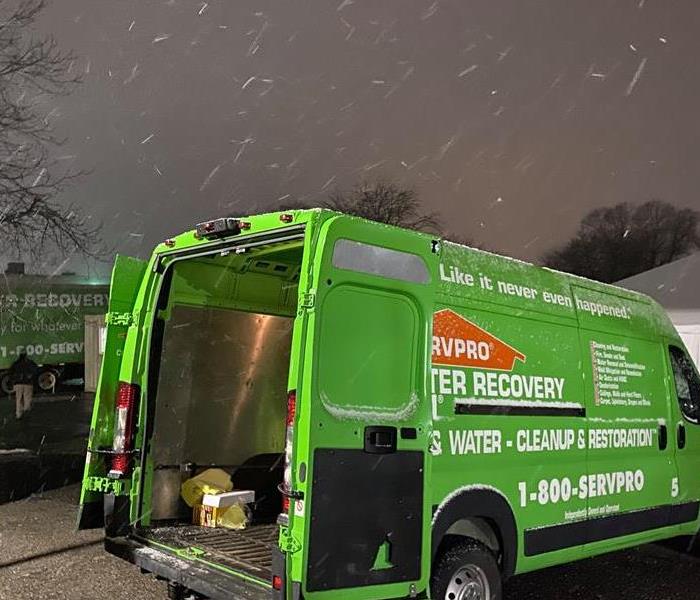 Snowy night with a green SERVPRO van.