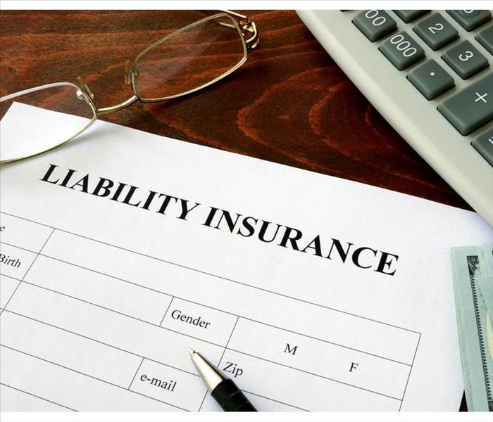 Liability insurance form and dollars on the table.